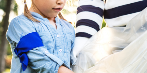 Kid and her mom putting garbage in a bag